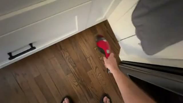 Aspirador passando em piso de madeira, gravado em primeira pessoa com a mão no cabo