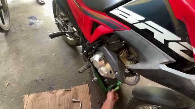 Limpeza de uma moto vermelha na garagem, gravada em primeira pessoa